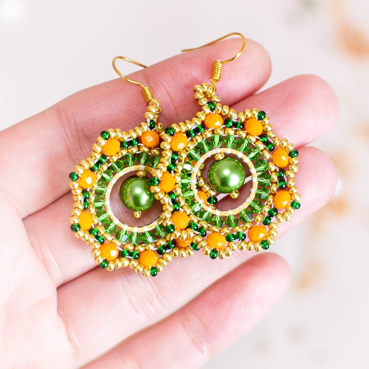 a pair of green and yellow beaded earrings